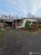 Plenty of parking! One spot under the carport with covered access to the ramp leading to the front deck/door. There is also a shed for storage! Welcome home!