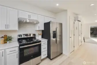 Contemporary kitchen with electric range, stainless refrigerator, and streamlined cabinetry designed for low-maintenance island living.