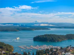 Aerial image capturing regional landscape with water views and distant mountain backdrop.