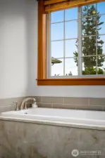 Relaxing soaking tub with natural light and private views.