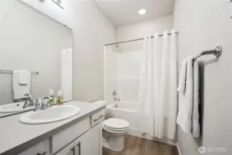 Full bathroom with generous counter space, huge mirror, and own linen closet