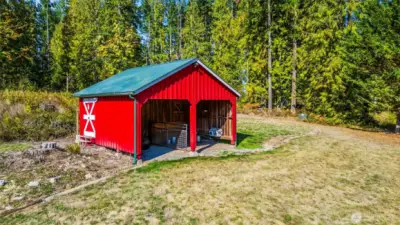 Another view of the barn / stable. The door to the enclosed portion can be seen with the white trim / cross bars towards the back.