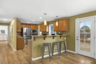 Your kitchen, half bathroom and laundry off of the back of the kitchen and looking down the hall to the primary bedroom.