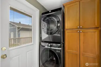 The half bathroom has a standing washer, dryer unit (replaced in 2022) and a large closet for linens or extra kitchen supplies.