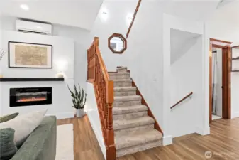 Stairway mid-way to go up to the primary top-floor suite or downstairs to another bedroom & flex space