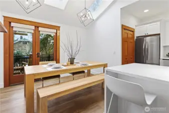 Gorgeous dining space with skylights, French doors out to the garden