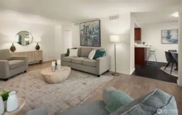 Living room flowing seamlessly into kitchen and dining area.