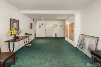 Entrance to condominium building featuring mail & elevator.