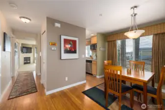 The view from the front door looking into the condo.  Warm bamboo floors anchor the entry, dining area, and kitchen in this light-filled corner unit.