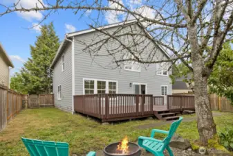 A view of the back of the home, showcasing the spacious deck and fully fenced yard!