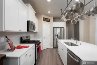 Chef's kitchen with panty, white cabinets and quartz counter tops.