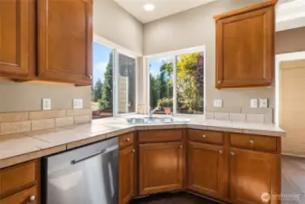 Kitchen overviews the private backyard with fruit years and an open field behind.