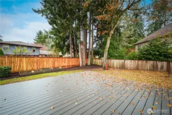 The fully fenced yard offers ample space for play or gardening, including raised garden beds.