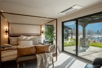 Primary bedroom with large glass sliding door opens to the lakefront patio.