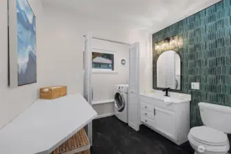 Stylishly updated lower-level 3/4 bath featuring a modern, chic, minimalist design, conveniently connected to the laundry room