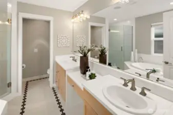 A spa-like primary bathroom awaits with a deep soaking tub, dual vanities, and tasteful tile accents—creating a serene and stylish retreat just off the bedroom.