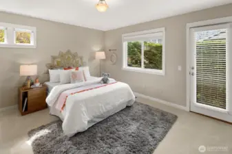 A glass door and multiple windows fill the room with natural light and offer peaceful views of the surrounding greenery—bringing the outdoors in.