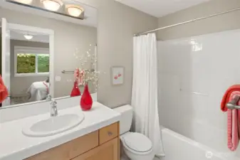 This full bathroom is ensuite to the second upstairs bedroom, offering convenience and privacy with a clean, timeless design and a tub/shower combo.