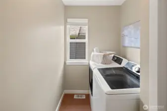 The laundry room is conveniently located upstairs near the bedrooms and includes a window for natural light and room to fold and sort with ease. New washer and dryer installed in 2024!
