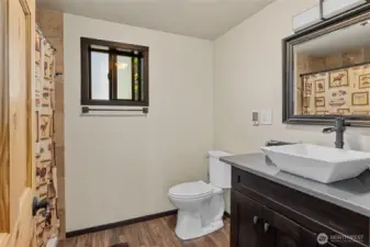 Main floor 3/4 awesome bath with showerhead + rainshower + jets! Heated tile floor & pretty vessel sink.