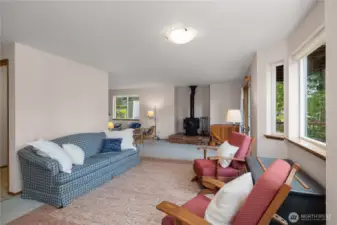 Living room  space cozies up to the wood stove.