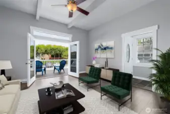 Bright and inviting living area with double doors opening to the deck. Photo Virtually Staged