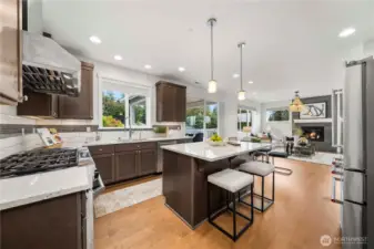 Chef’s kitchen with slab quartz countertops, oversized island & stainless appliances