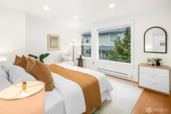 King size primary bedroom with picturesque windows and custom closet shelving.