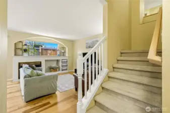 Entry with hardwood floors and staircase leading upstairs.