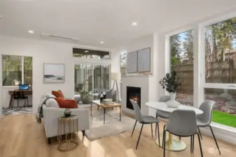 Step into the heart of the home—a cozy yet airy living room bathed in natural light. The fireplace creates a warm focal point, while large windows bring the lush outdoors inside.