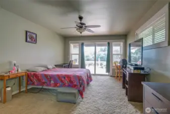 Down the hall into the primary suite, the bedroom is very spacious and has a ceiling fan to keep the beach air moving in the summers!