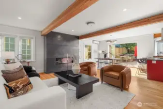 Spectacular great room features a stunning blackened steel encasement surrounding the gas fireplace, gorgeous hardwood floors, beautiful wood beams, dining room and tri-fold doors that spill out to the entertainment deck.