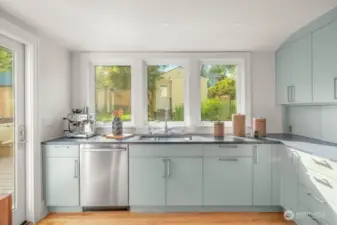 The softer tones meld right into the garden. These picture windows are delightful to look out as one washes dishes and prepares meals.  Notice the appliance garage just disppears to the right. High end appliances.