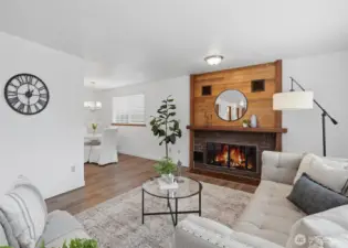 Expansive windows and a cozy wood-burning fireplace create an inviting space to gather or unwind.