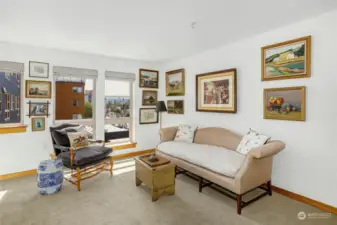 The bright living room, featuring numerous south-facing windows, is filled with natural light and sunshine.