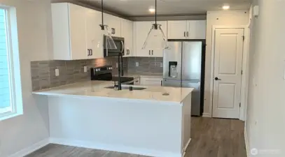 Sky White Quartz Counters, Matte Black Hardware and Fixtures. Includes all Whirlpool appliances.