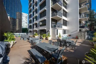 Pool deck off clubhouse w/ lawn chairs, outdoor seating/couches. gas firepit and BBQ's.