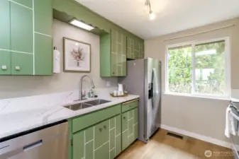 This view of the kitchen shows the new quartz countertops, stainless steel appliances and new sink.