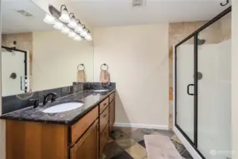 Large full bathroom off primary bedroom with tile floors and spacious shower