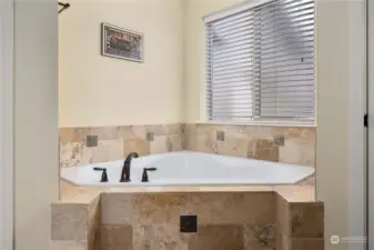 Relax in this oversized corner tile-surround bathtub
