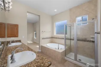 Large Primary bathroom featuring full tile shower, tub, double vanity and grantie countertops.