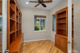 Den/Office with custom built-in shelves and hardwood floors.