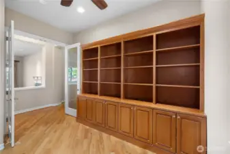 Den/Office with custom built-in shelves and hardwood floors.
