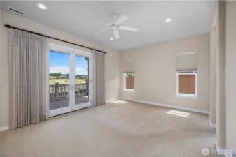 Primary bedroom featuring French doors to covered porch and blackout blinds for comfort.