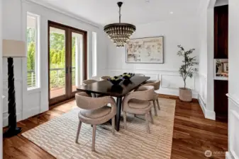 Striking detailing abound in this elegant dining room. Gorgeous lighting, wainscotting and French Door leading to a deck for BBQ's or just letting in the flowing breeze!