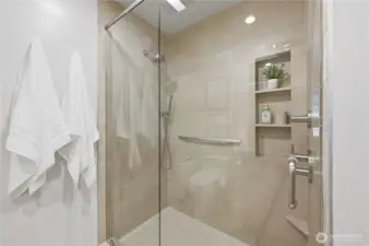 Check out this incredible full glass walk-in shower with built-in shelves for convenience.