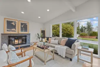 Light-filled living room with vaulted ceilings, recessed lighting, and a stunning brick fireplace.