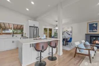 Updated kitchen featuring quartz countertops, new cabinetry, stainless steel appliances, and a generous center island with seating.