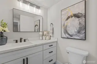 Remodeled primary bath with tiled walk-in shower, quartz vanity, and modern fixtures.