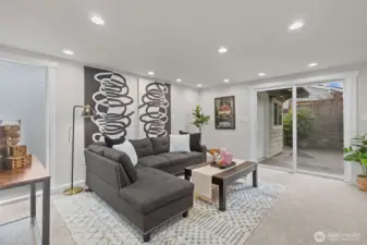 Spacious main-floor family room with recessed lighting and sliding door access to the private side patio—ideal for entertaining or relaxing.